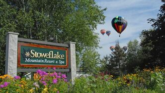 Stoweflake Mountain Resort & Spa sign in spring with hot air balloons in background